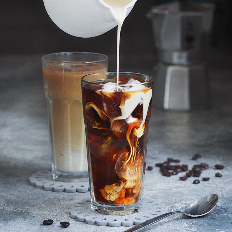 Campout Cold Brew (Dutch Bros Copycat) in a glass with pouring milk swirling in